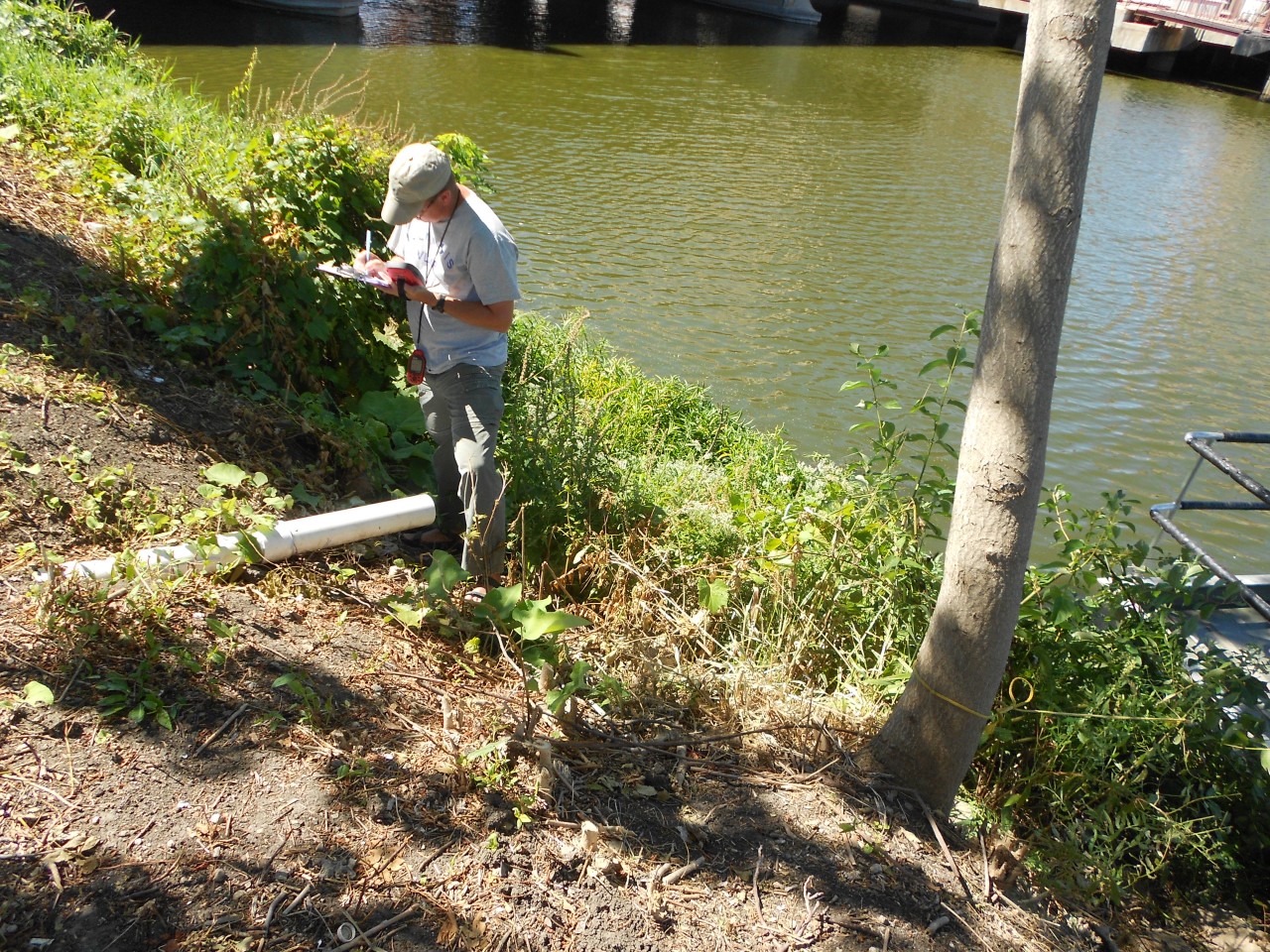 Scientist monitors to gather data on outfalls and pipes that discharge into a river. This identifies illicit discharges.